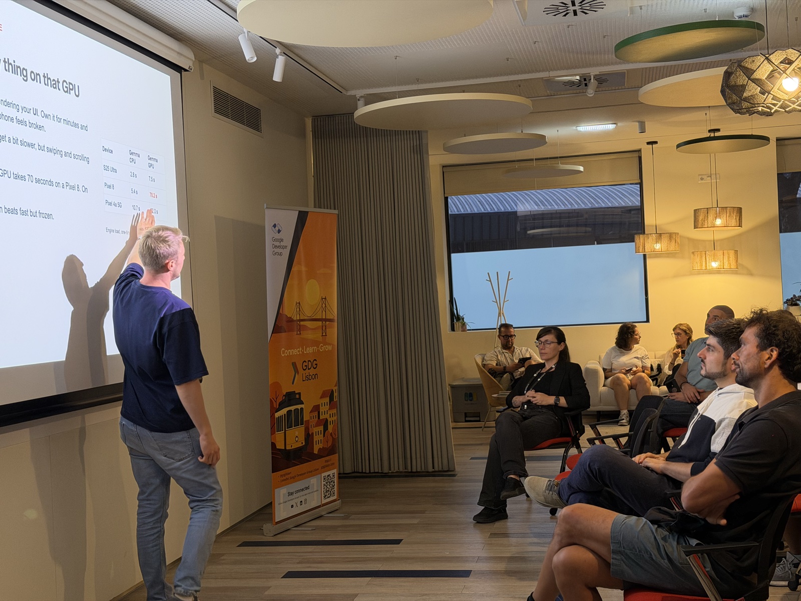 Dmytro Samoilov presenting Gemma CPU vs GPU benchmark numbers for on-device AI at the GDG Lisbon meetup hosted by Critical Software